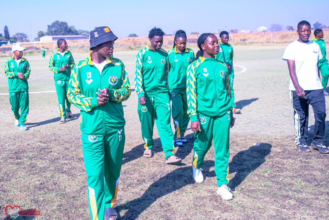 Players in club tracksuits walking across the pitch before a match